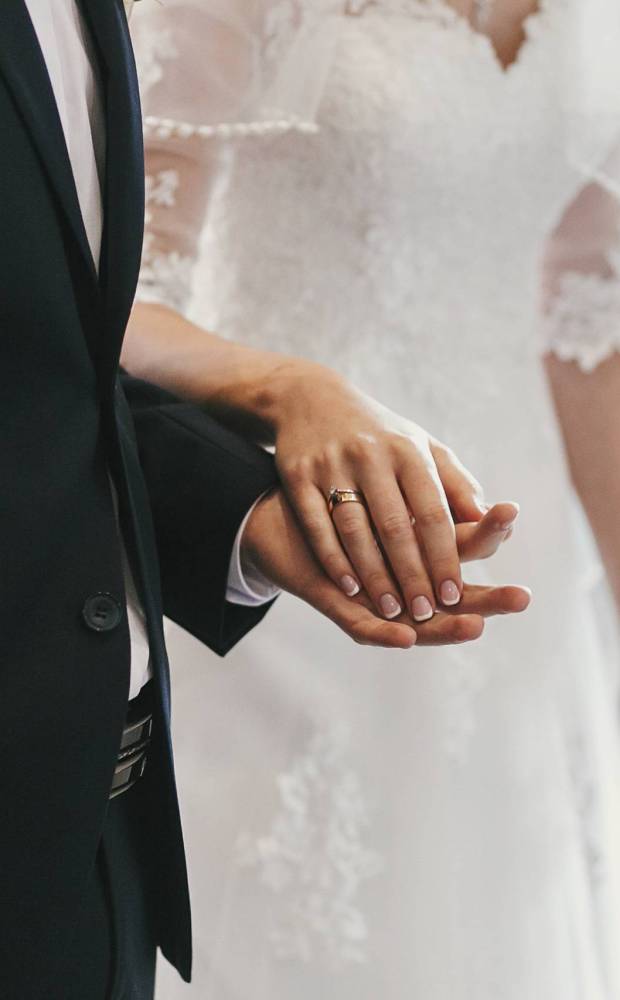 beautiful bride and groom hands exchanging wedding rings in church during wedding ceremony. spiritual holy matrimony. wedding couple and priest putting on rings